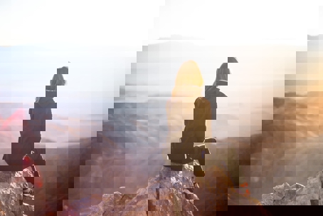 woman sitting outside alone in front of mountain view