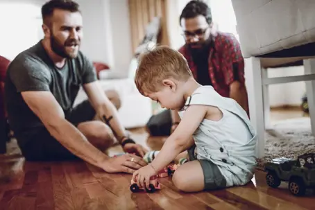 Little boy playing on the floor with dads