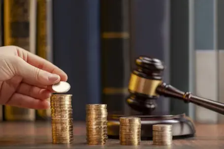 Gavel with coins on a table