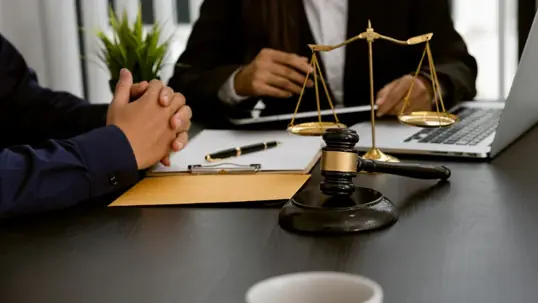 Lawyer discussing contract documents sitting at a desk