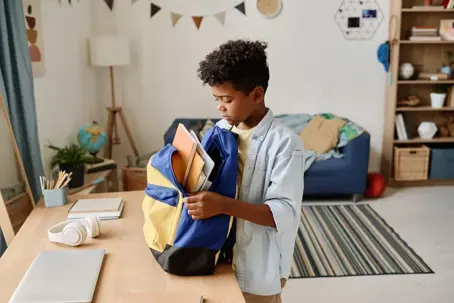 Boy packing his backpack for school