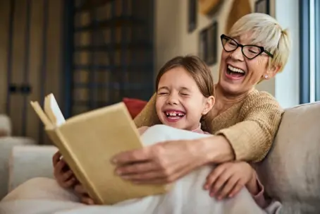 Grandparent reading with their grandchild on the couch