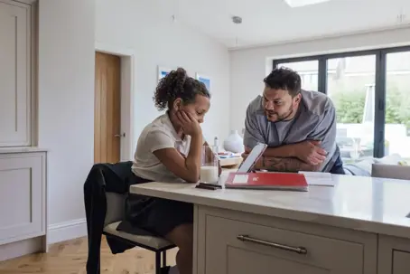 Dad talking to daughter while sitting in the kitchen