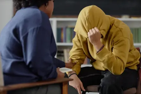 Teenage boy talking to a caring adult