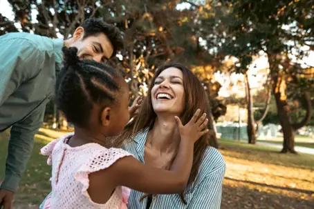 Women laughing with little girl