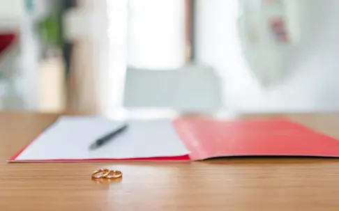 Wedding rings with documents blurred in the back