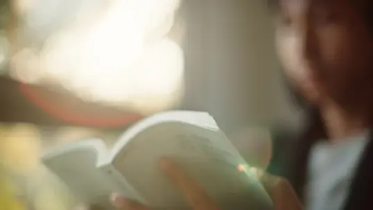 Blurred out teenager reading