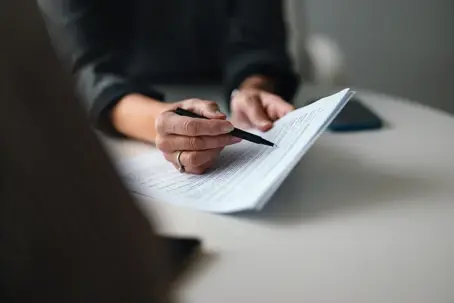 closeup of a person signing a document