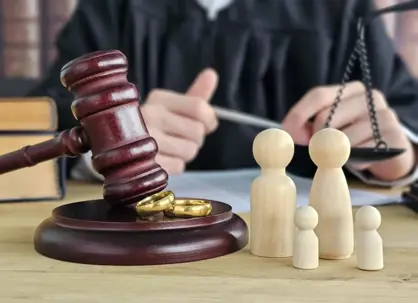 Gavel with wedding rings and wooden family figures
