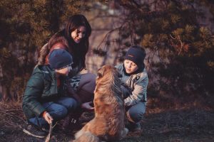 Mother and her sons playing with a dog